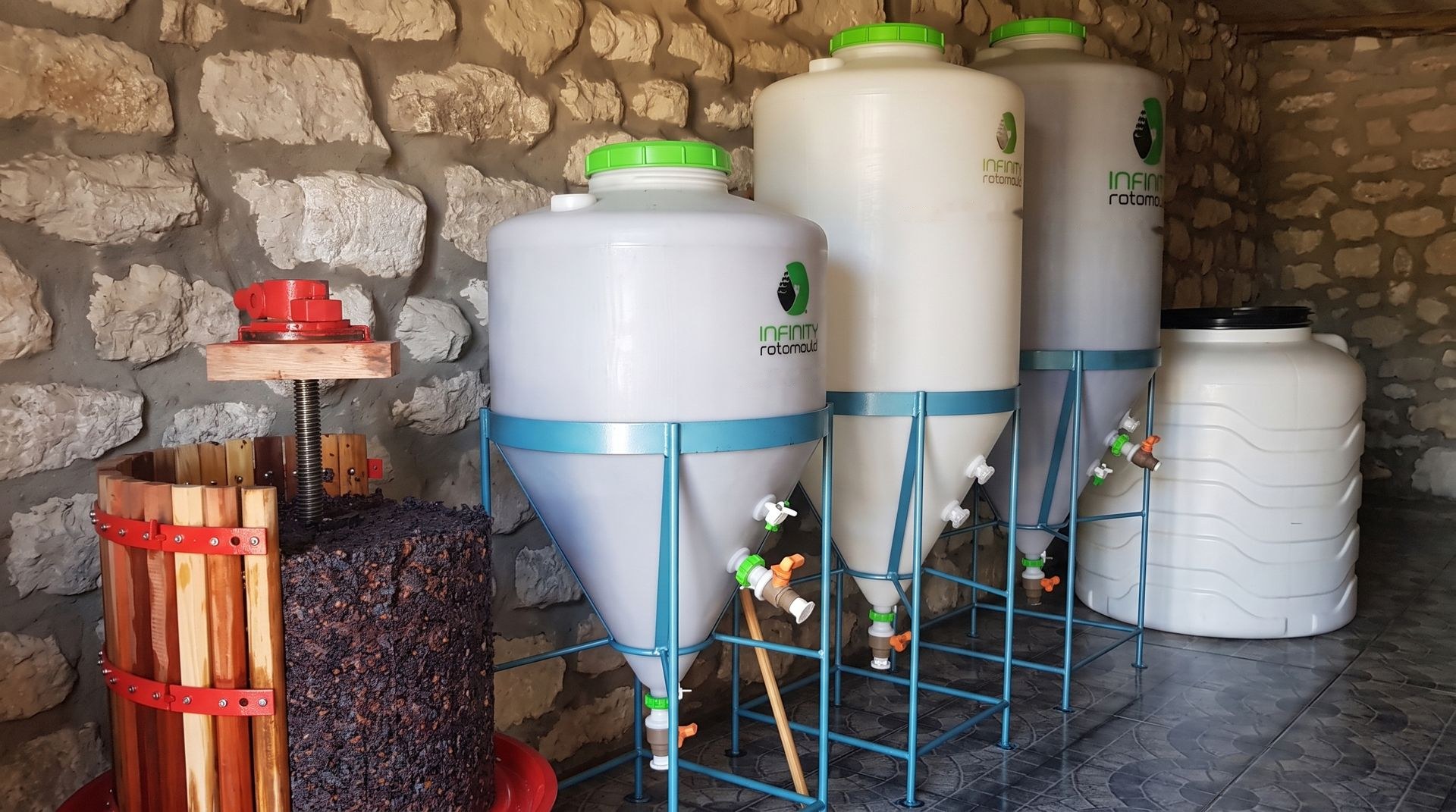 Fermentadores cónicos y tanques de fondo plano instalados en una bodega